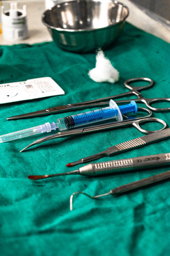gallery-01 Close-up of dental tools and syringe on a green cloth, showcasing a sterile healthcare setup.